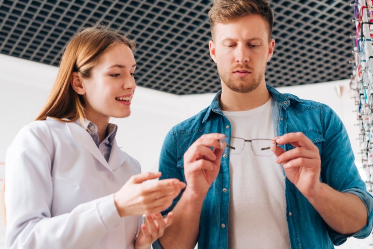 Opticien conseillant un client lors du choix de nouvelles lunettes pour renouveler sa correction visuelle